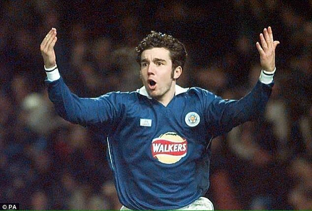 Muzzy Izzet in a blue Leicester City shirt, arms raised, appealing to the referee